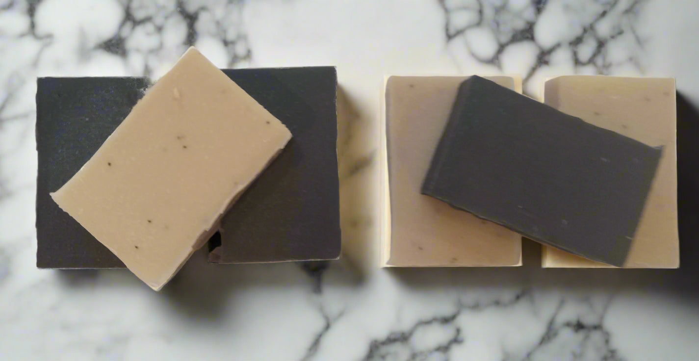 Two sets of black and beige soap bars on a white surface